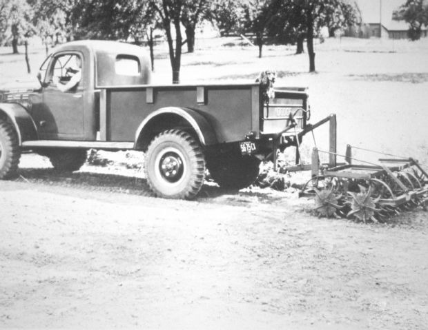 Power Wagon pulling a disc harrow with a dog in the bed